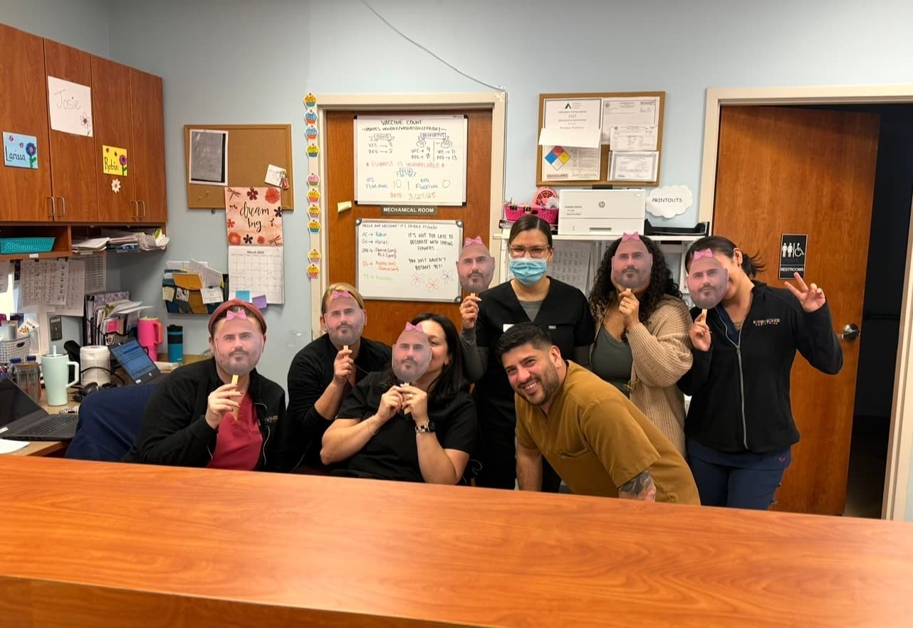 Warren staff posing with face masks on sticks